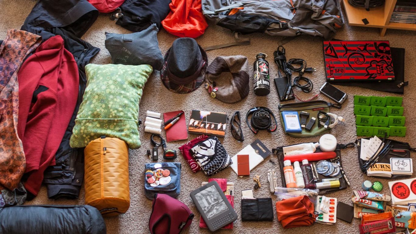 Essential gear for the Tongariro Alpine Crossing hike, including hiking boots, water bottles, and a backpack with outdoor supplies.