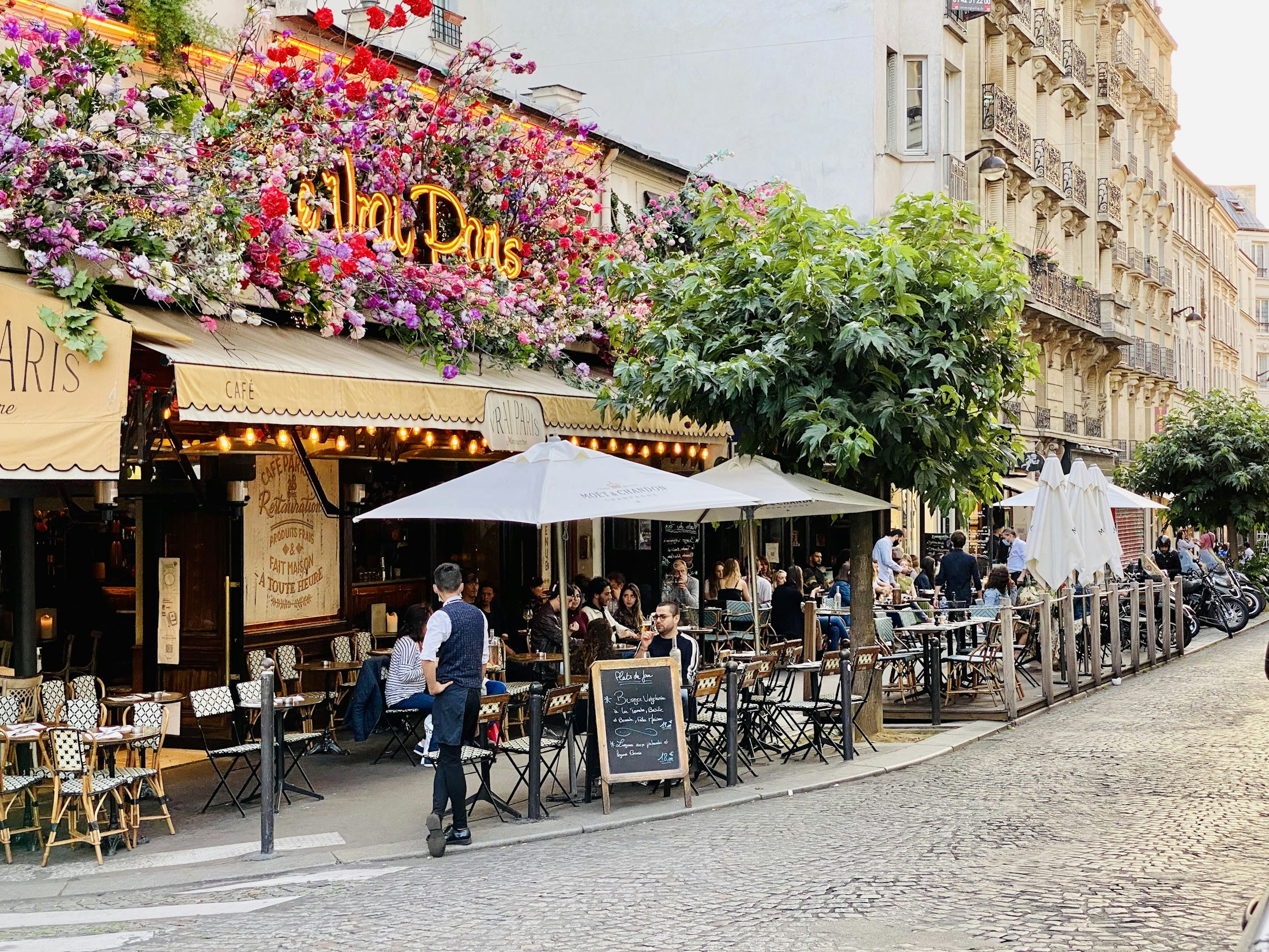 Flower-covered café terrace on a street in Montmartre, Paris